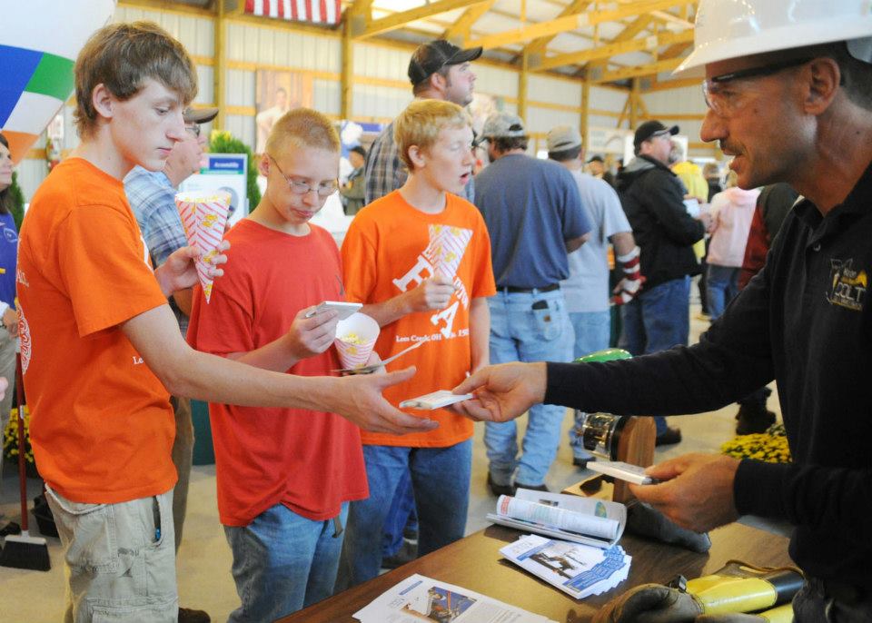 A man handing out items to youth during an event