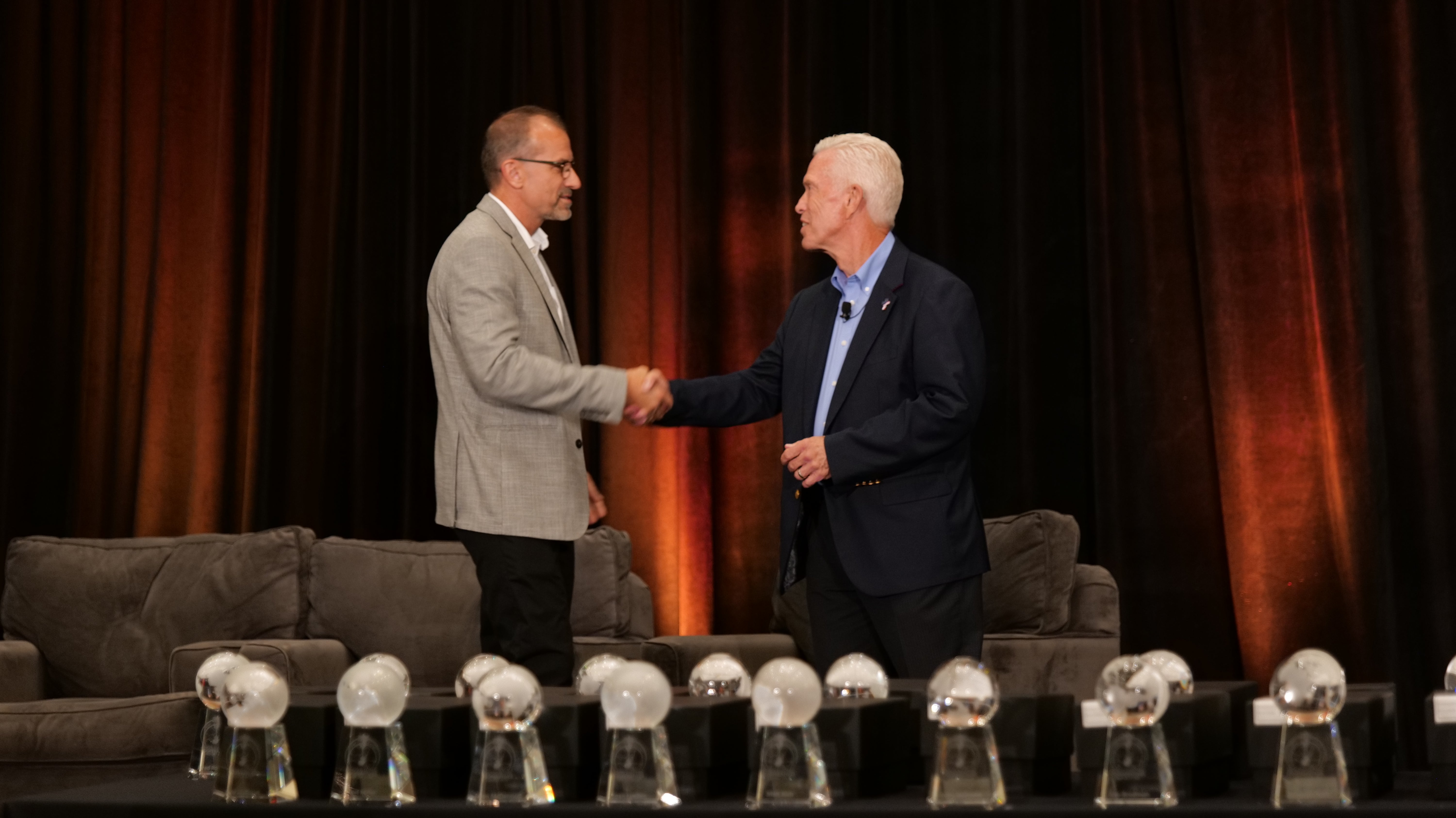 Two men shaking hands on stage