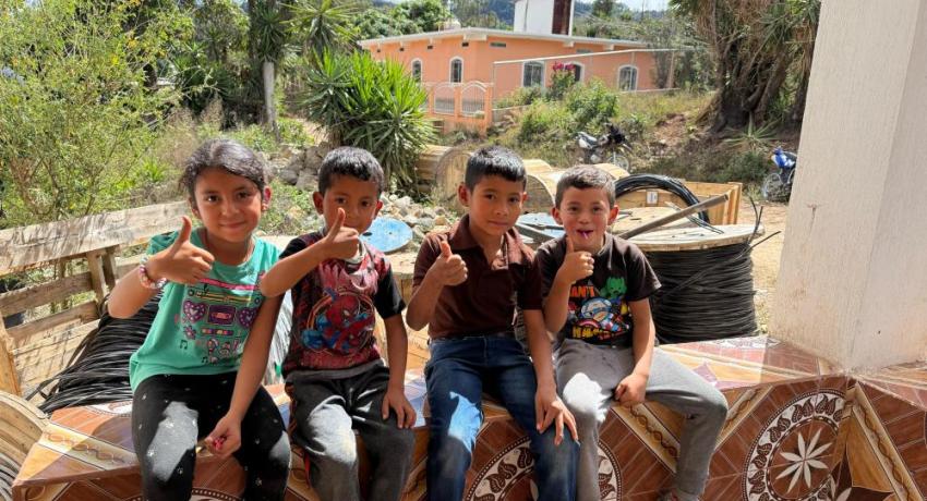 Four Guatemalan kids giving a thumbs up