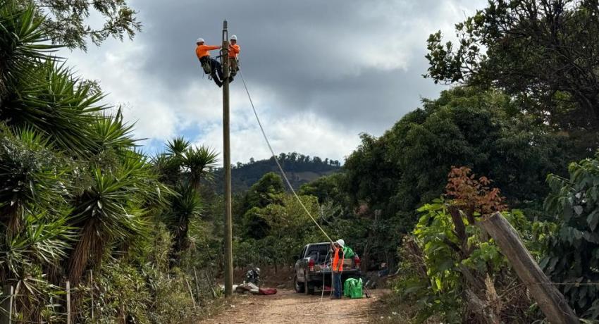 Two lineworkers on a utility pole in Guatemala