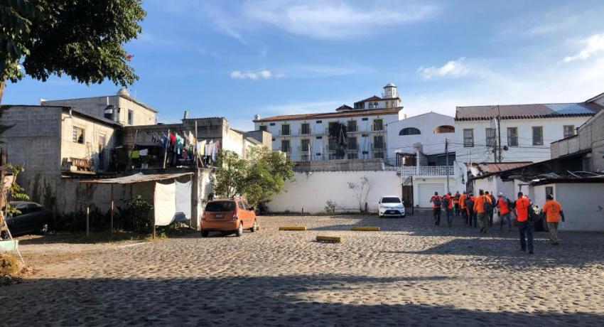 A group of lineworkers walking through a village in Guatemala