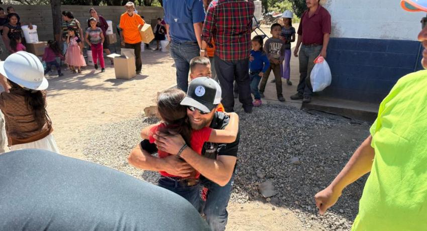 A lineworker hugging a young Guatemalan girl